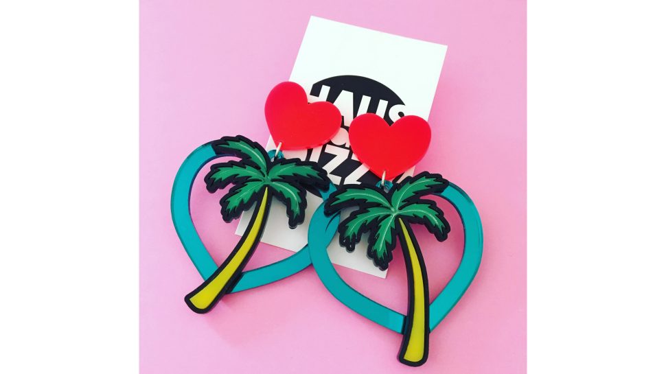 A pair of earrings in the shape of Hawaiian palm tree cut outs.